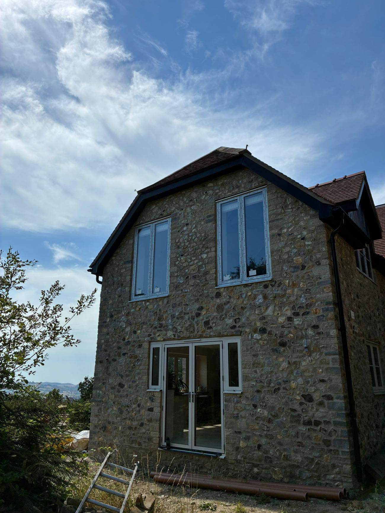 New house gable built in local Dorset rubble stone with a clay tile roof