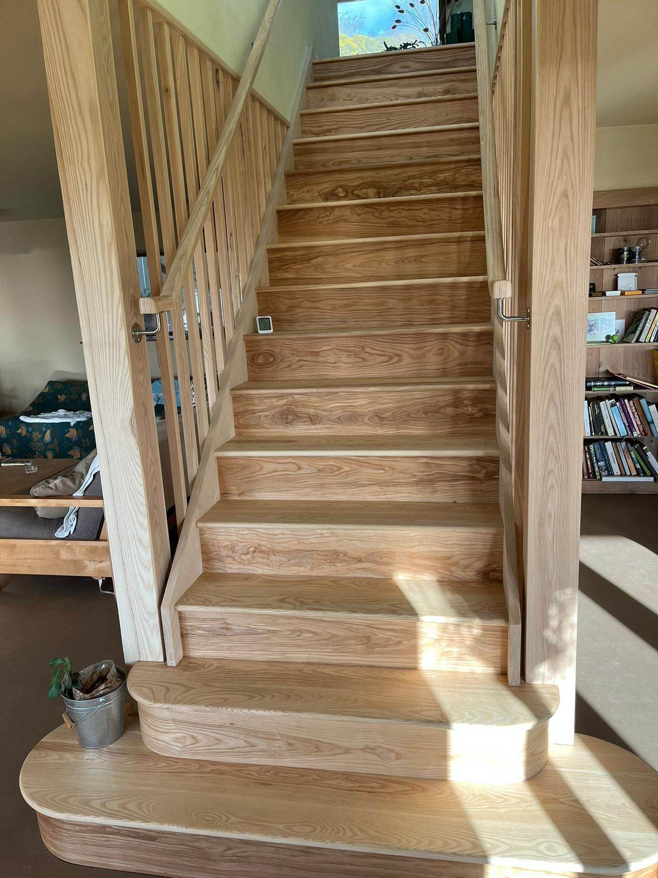 Ash staircase with curved bullnose treads and a timber handrail