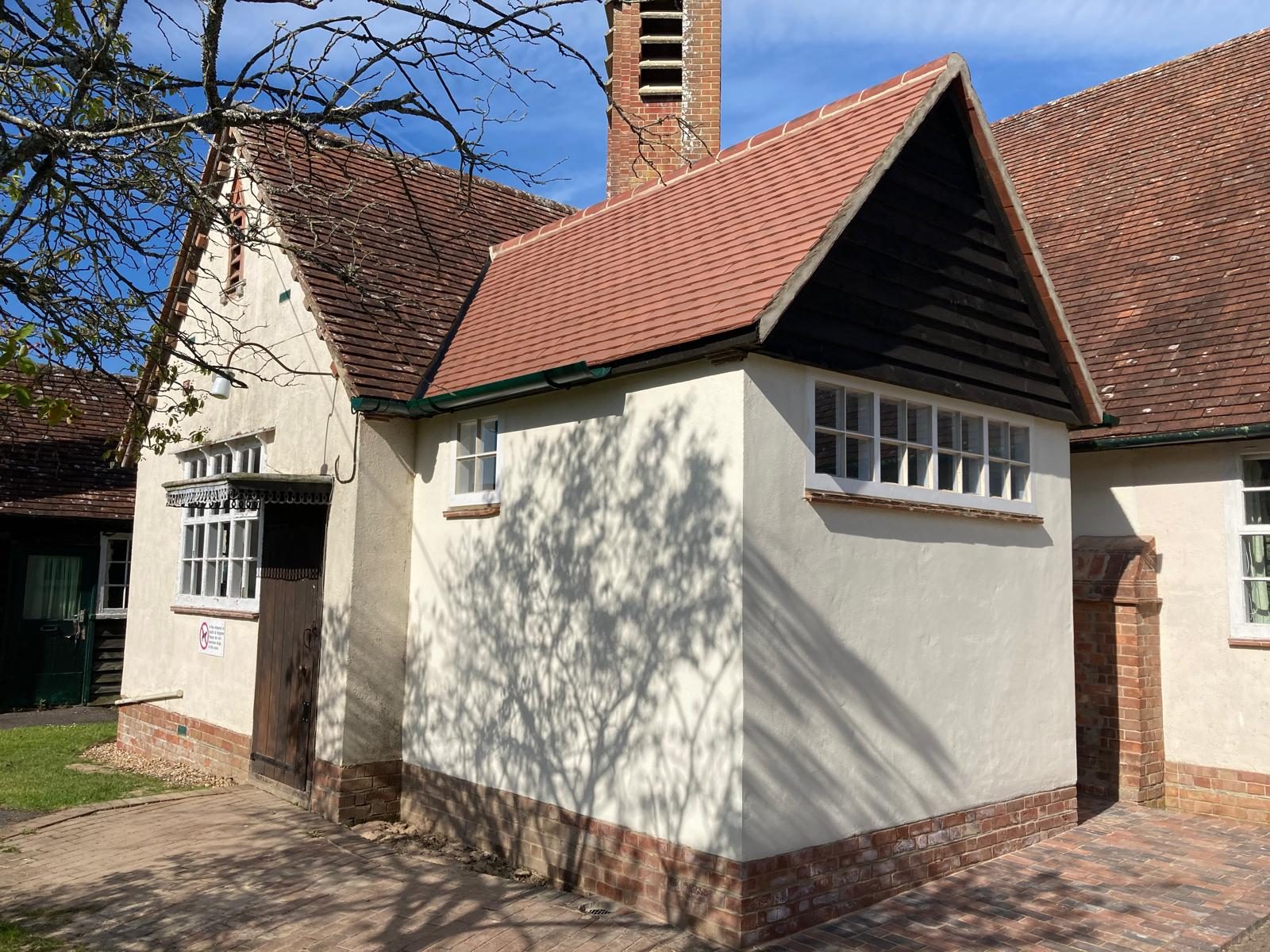 Rendered cottage with clay tile roof and black timber gable, West Dorset