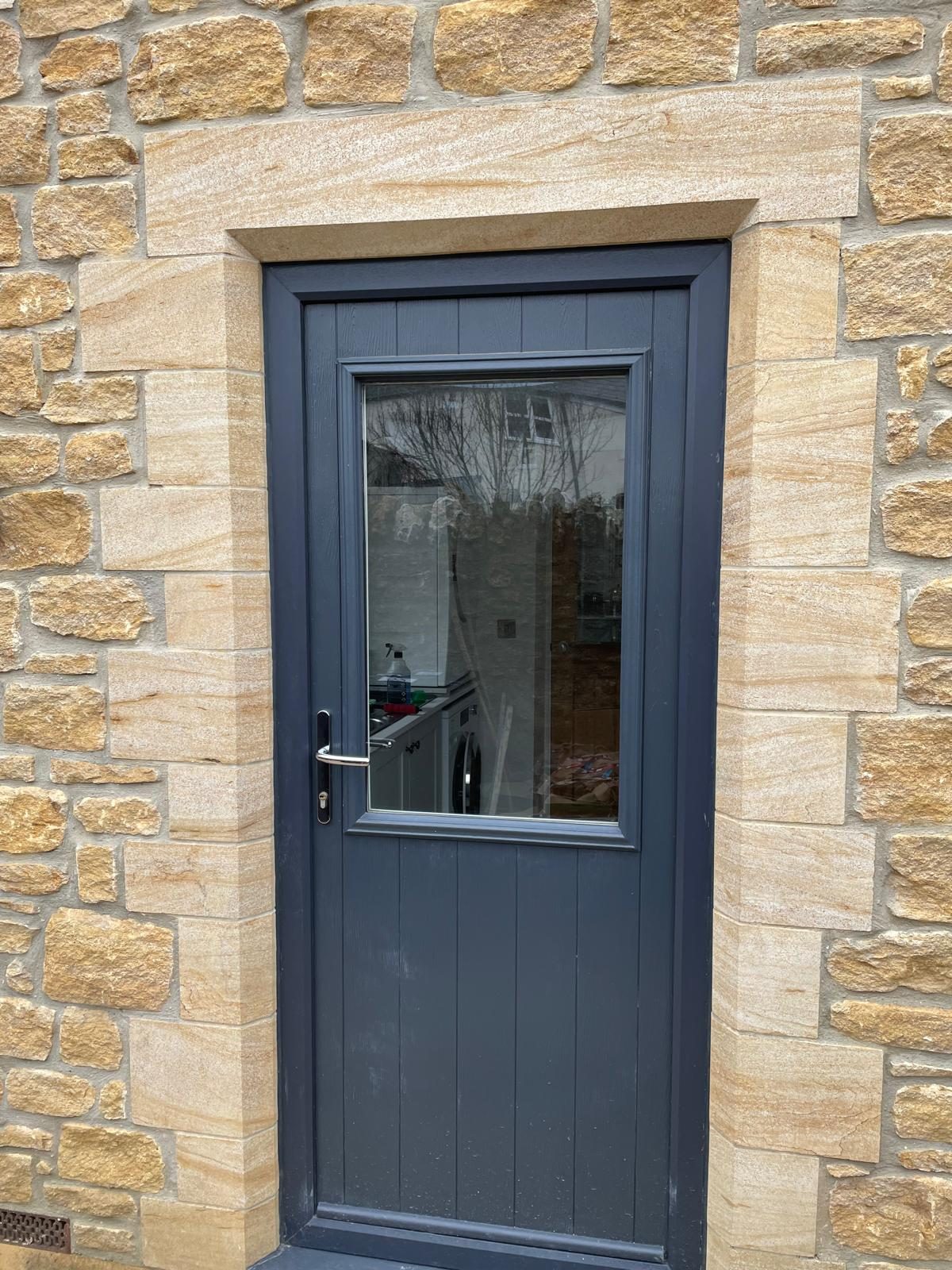 Grey composite door set in a dressed stone surround