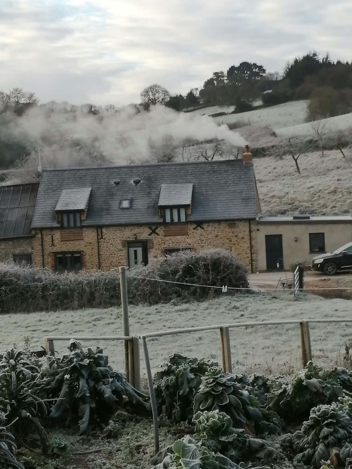 Converted stone barn with a slate roof on a frosty morning, West Dorset